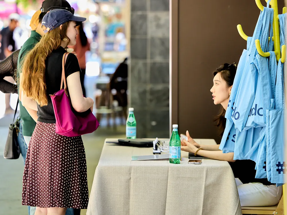 Visitors chatting with the sudo team at a bothaus welcome table