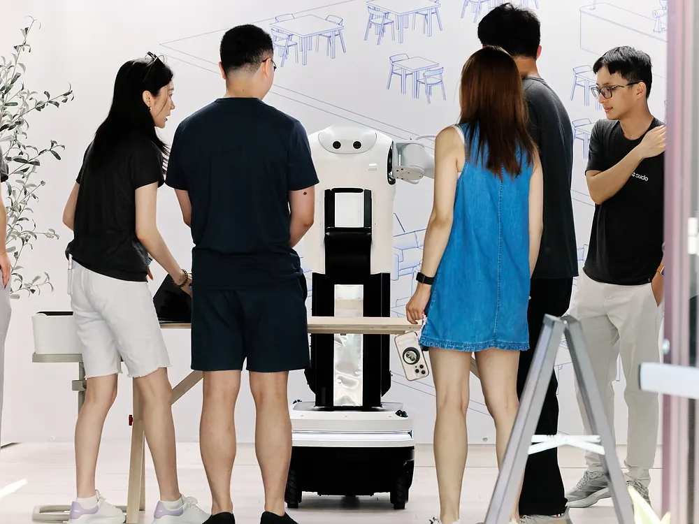 Visitors watching the sudo robot at a demo table