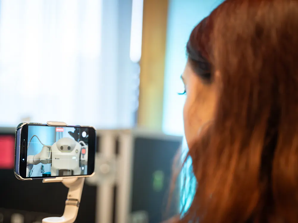 A visitor recording the sudo robot on a phone gimbal